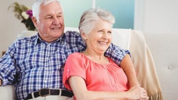 happy retired couple relaxing on couch