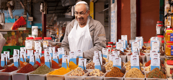 Man selling spices at an open market.