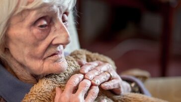 cold elderly woman under blanket