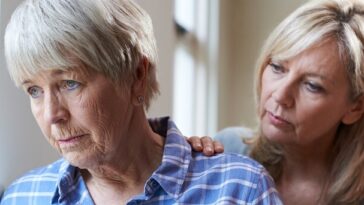 woman looking with concern at mother with dementia