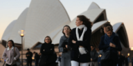 people dressed in winter clothes in front of sydney opera house