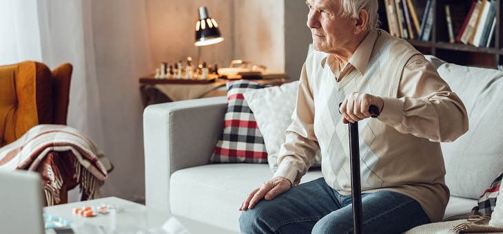 elderly man with cane sitting on couch