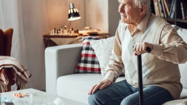 elderly man with cane sitting on couch