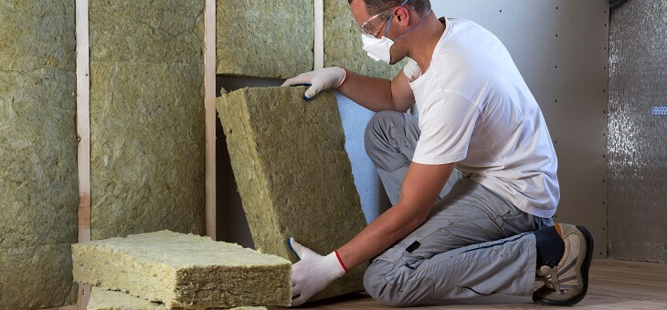 man installing insulation in roof cavity