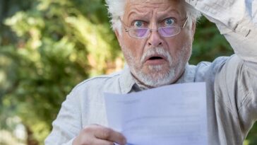 older man reading a letter with shock