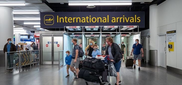 passengers walking through international arrivals gate at airport