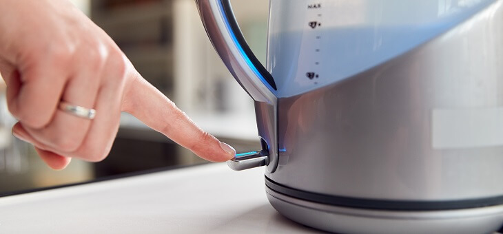 woman's hand turning on kettle