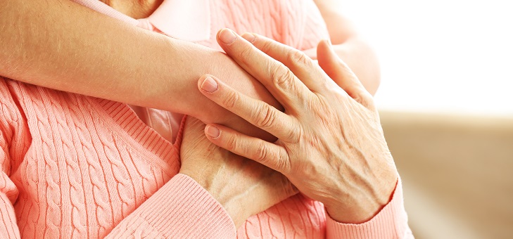 hands of young woman hugging elderly woman
