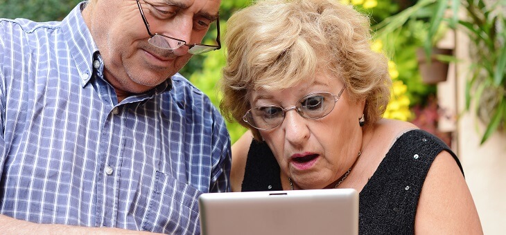 shocked older couple looking at ipad