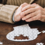 man doing jigsaw puzzle of human head with pieces missing