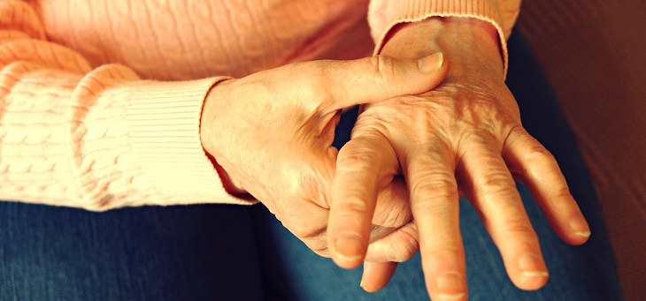 elderly woman rubbing arthritic hands