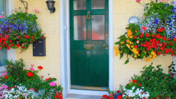 Front door surrounded by flowers