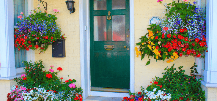 Front door surrounded by flowers