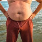 fat man on beach in summer