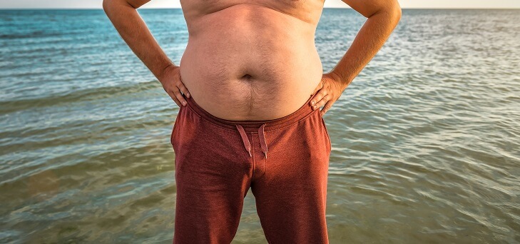 fat man on beach in summer