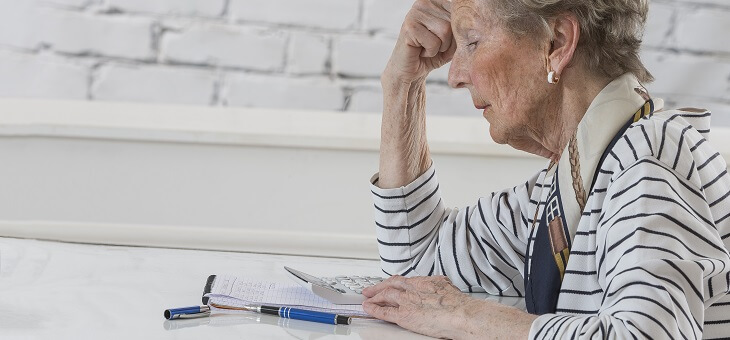 stressed older woman looking at bank statement