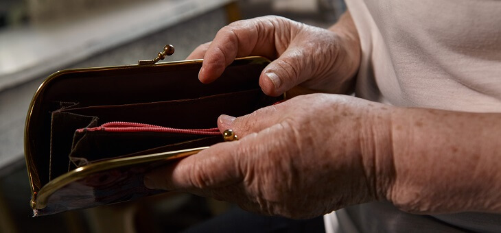 elderly woman looking in empty purse