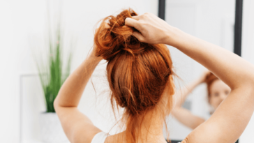 Red head putting her hair up in a bun