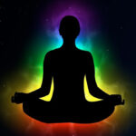 silhouette of person meditating with coloured aura