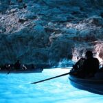 tourists in canoe going through Italian grottos
