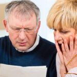 couple looking in shock at mortgage bill