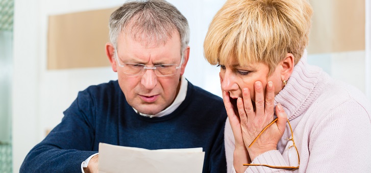 couple looking in shock at mortgage bill