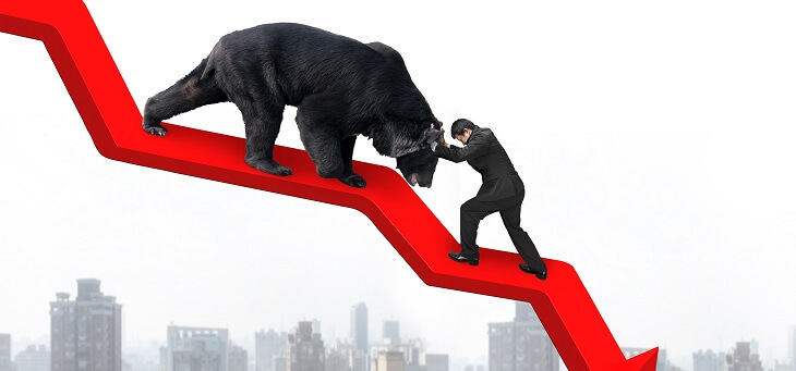 man pushing bear market on downward line graph