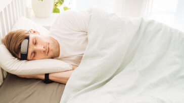 man in bed wearing brain monitoring device