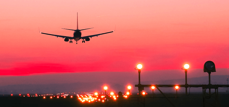 Plane landing during a red sunset