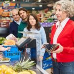 woman at checkout who is struggling pay grocery bills