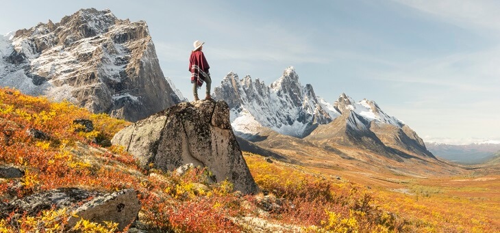 hiker standing on rocky outcrop, yukon canada