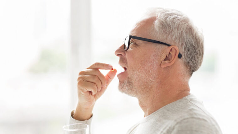 man taking pill to treat asthma