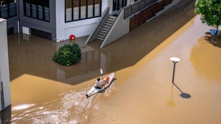 man paddling through a flood