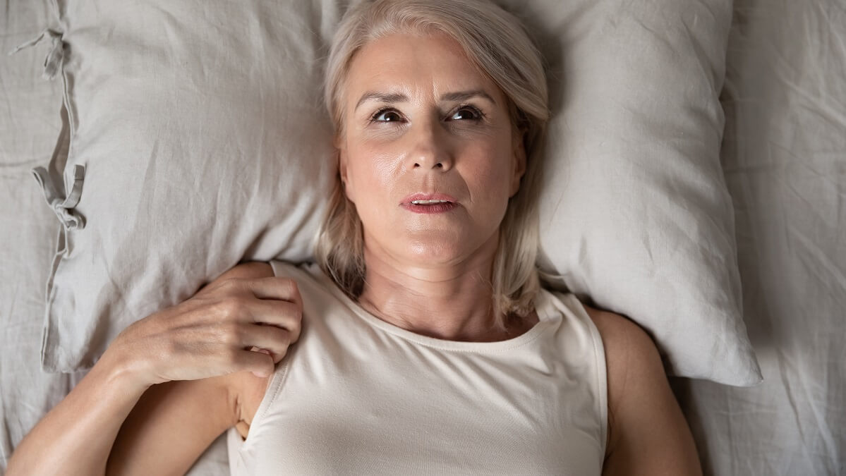 woman lying awake in bed after nightmare