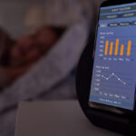 phone beside bed showing sleep tracking app