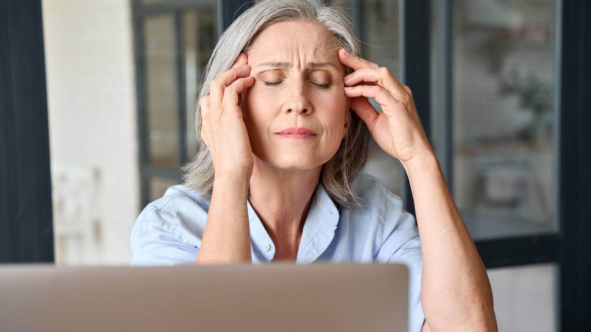 Woman looking stressed with her eyes closed