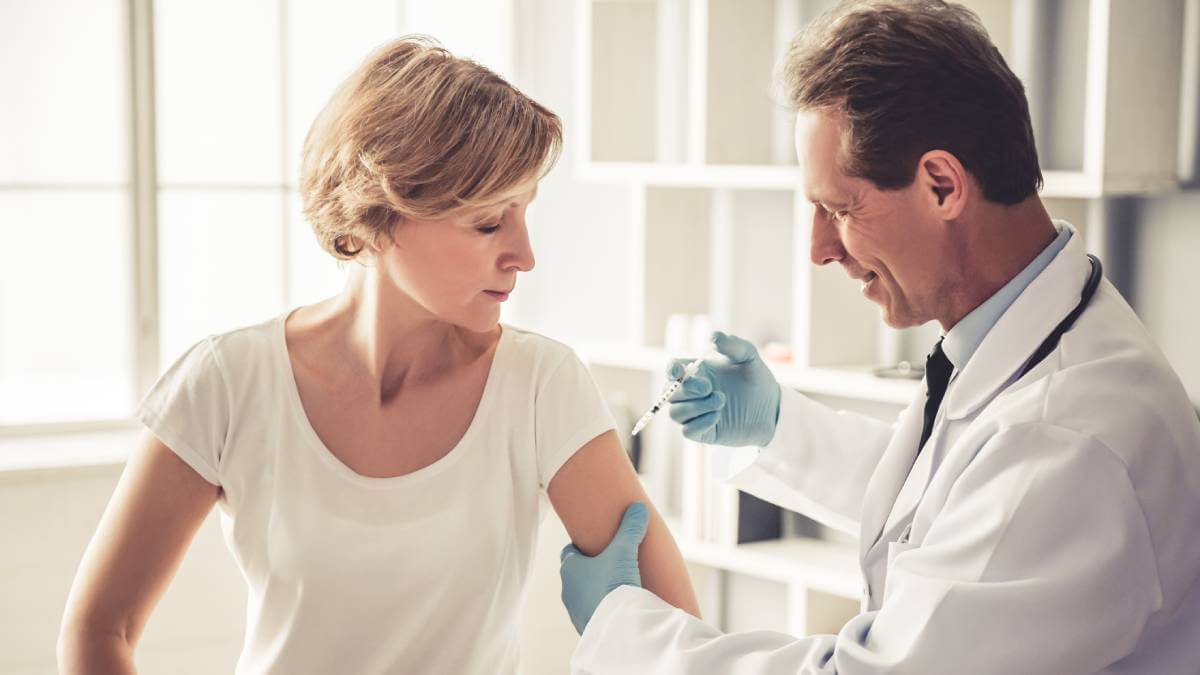 Woman getting a vaccination in her arm from a doctor