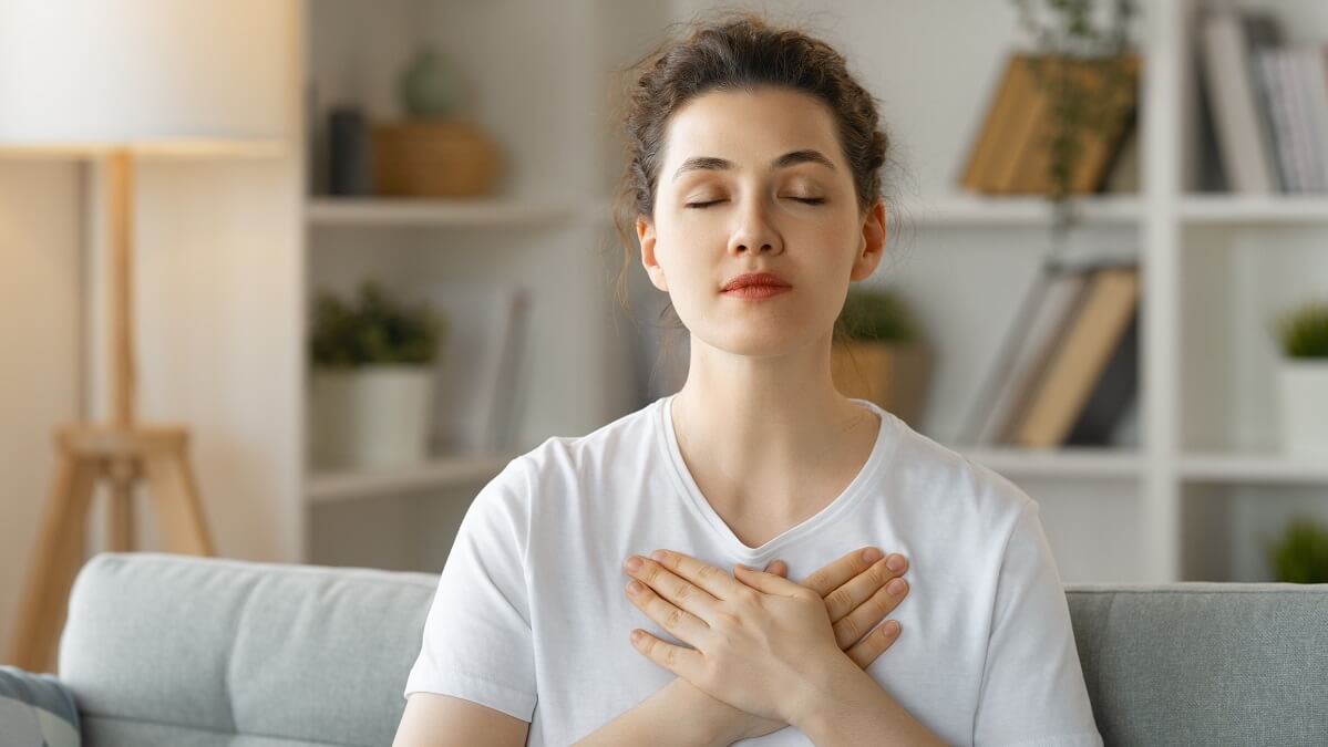 woman doing breathing exercise to lower blood pressure