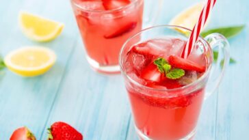 Two red drinks with ice and fruit