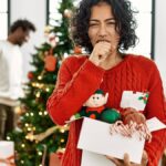 woman coughing in front of christmas tree