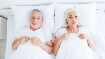 happy older couple in bed after doing exercises to improve their sex life