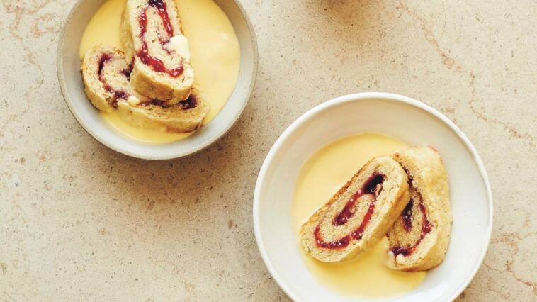 Jam roly poly in a bowl with custard