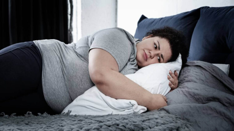 Overweight woman trying to sleep