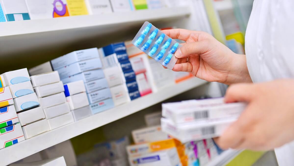 pharmacist stacking antibiotics on shelf