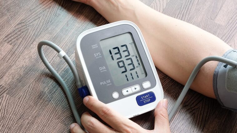 person using blood pressure monitor
