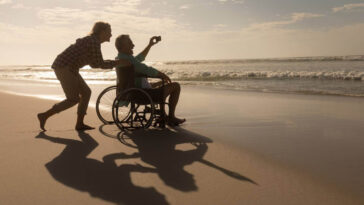 man in a wheelchair enjoying the beach