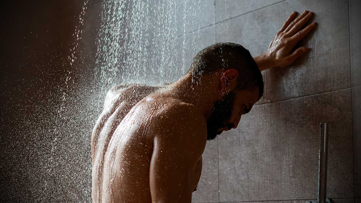 naked man enjoying the health benefits of a cold shower