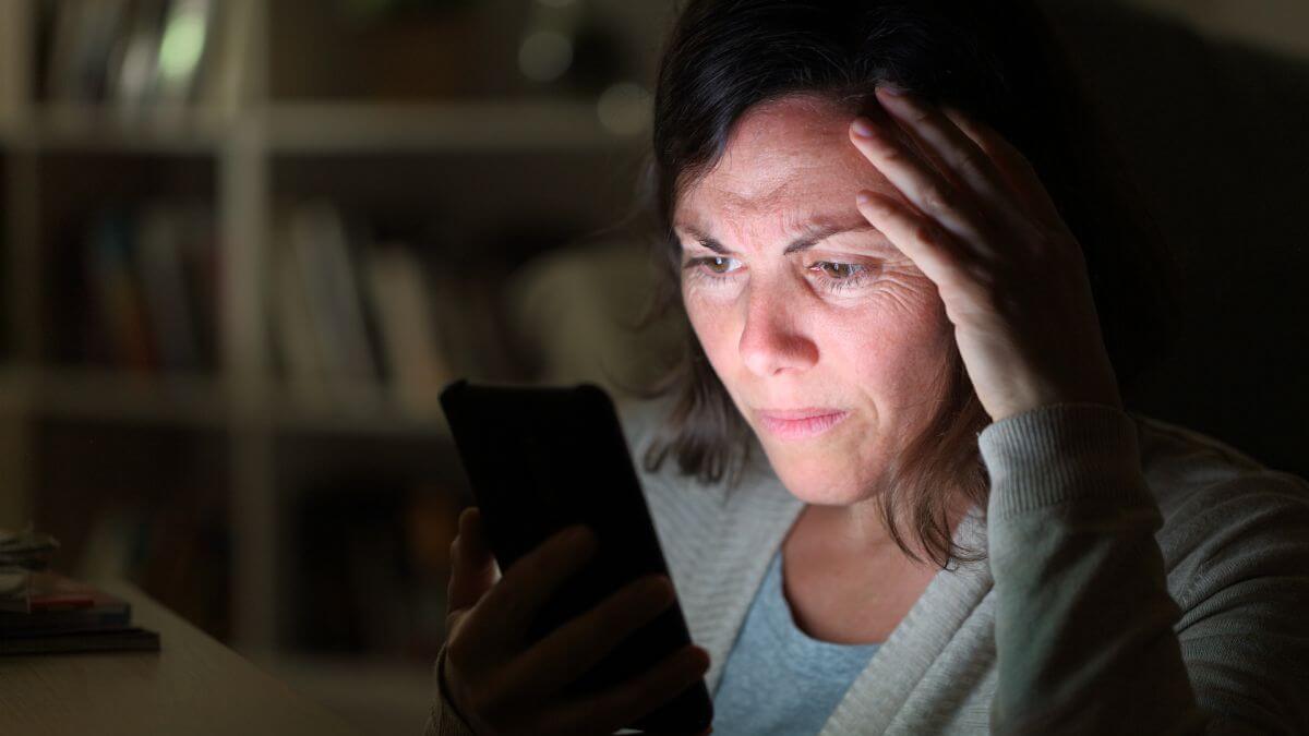 Woman looking sad at her phone