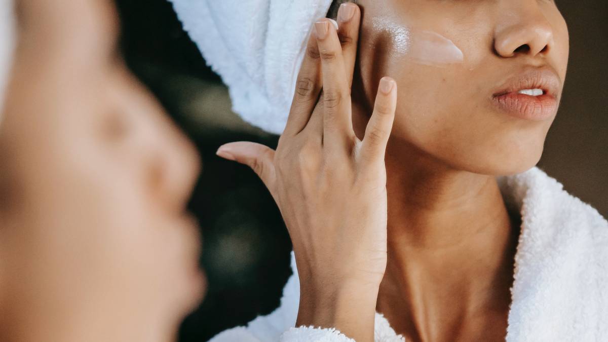 Woman putting moisturiser on her face