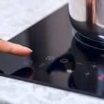 woman using electric cooktop